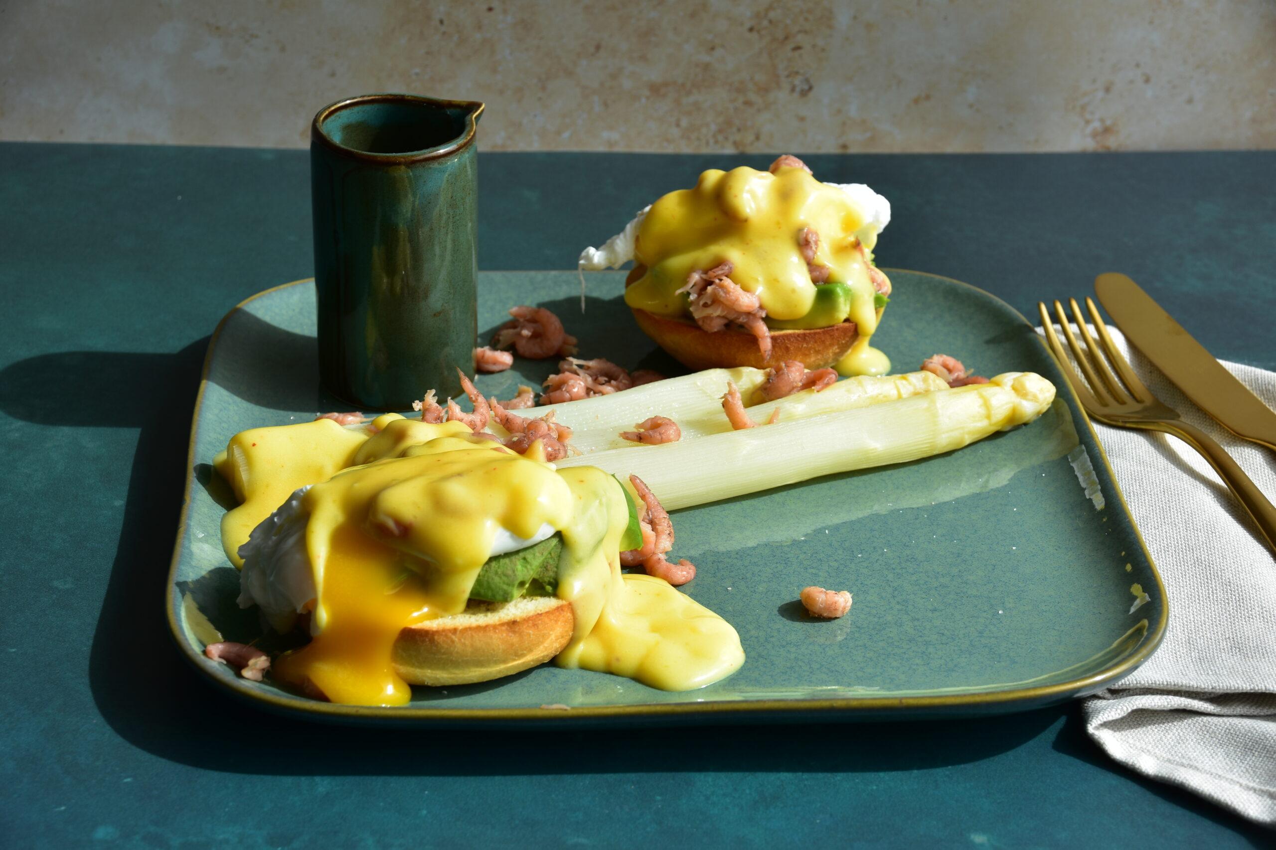 Eggs Benedict met avocado en grijze garnalen